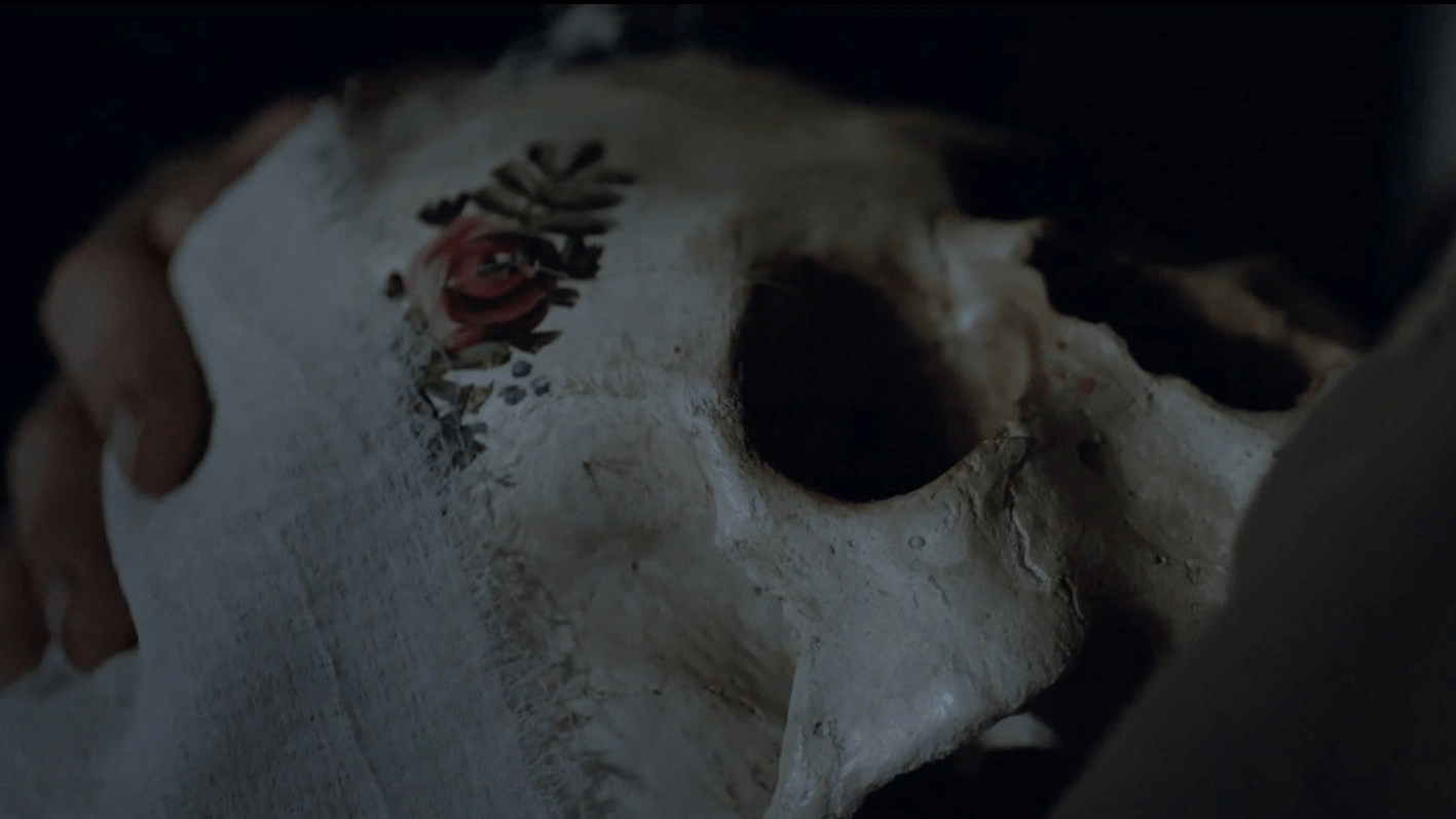 Hagazussa - Albrun tient dans ses bras le crâne peint aux fleurs de sa mère.